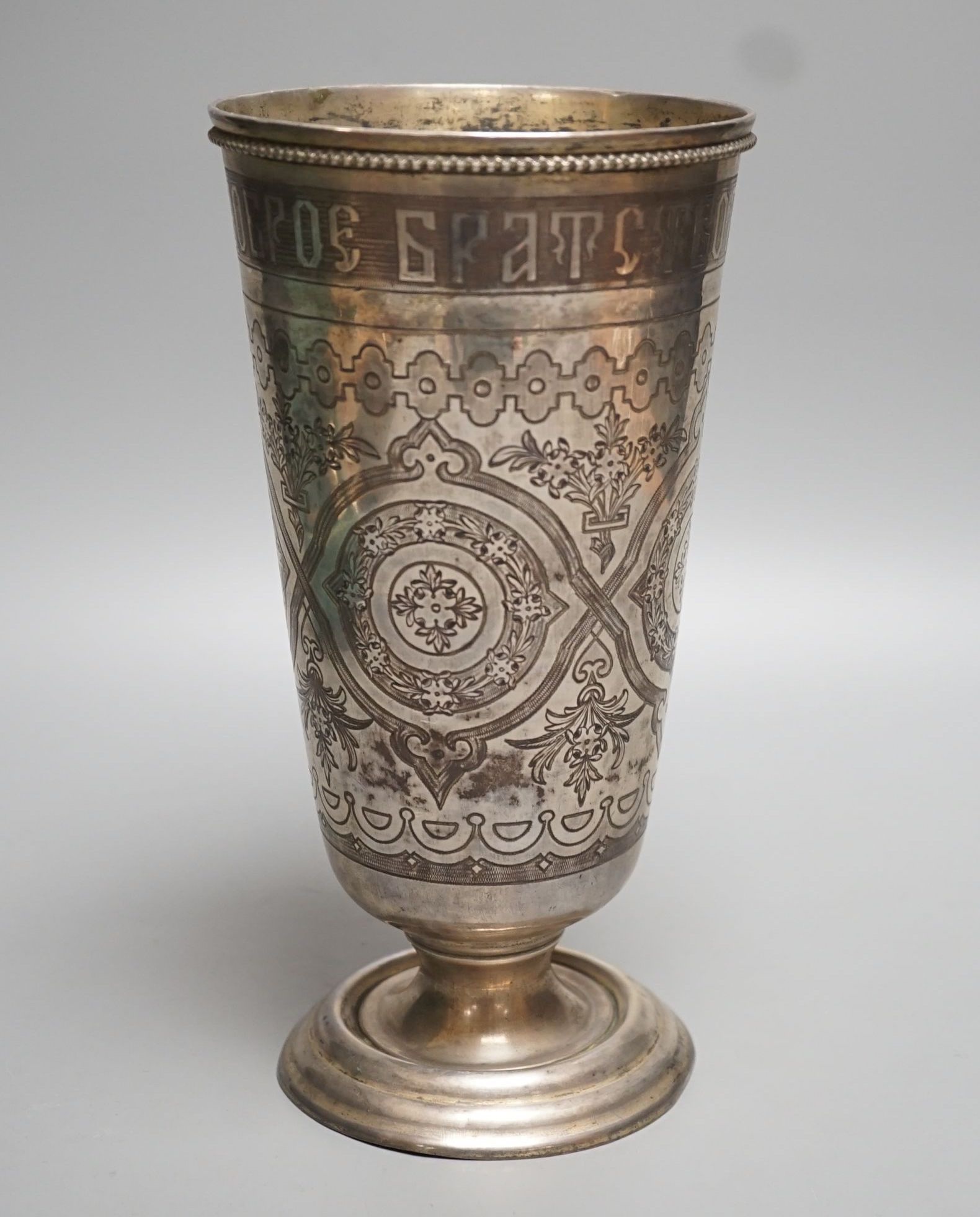 A continental white metal and niello vase, with inscription and decorated with foliate scrolls, 22.6cm, gross 15oz.